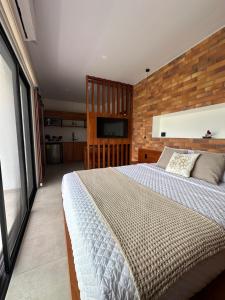 a bedroom with a large bed with a wooden wall at Roys Suites Galapagos in Puerto Ayora