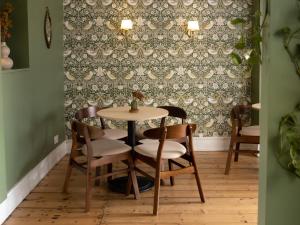 a table and chairs in a room with wallpaper at House Arundel in Arundel