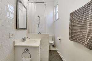 a white bathroom with a sink and a toilet at Spacious Chicago Group Home! Walk to Train & Eats in Chicago +13 photos
