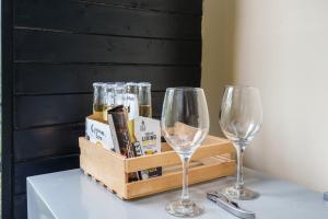 two glasses and a crate of wine on a table at Tiny House La Silleta in Medellín