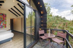 a room with a balcony with a bed and a table and chairs at Tiny House La Silleta in Medellín
