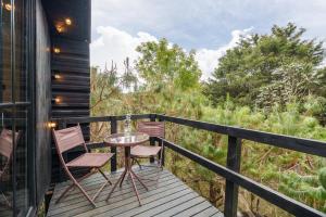 a deck with chairs and a table on a house at Tiny House La Silleta in Medellín +15 photos