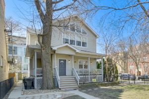a white house with a tree in front of it at Spacious Chicago Group Home! Walk to Train & Eats in Chicago