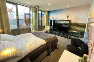 a bedroom with a bed and a flat screen tv at The London Skyline Penthouse in London