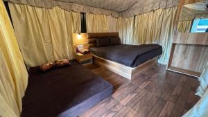 a bedroom with two beds and a couch at ARANYAM By StarGlaze Retreat in Mahabaleshwar