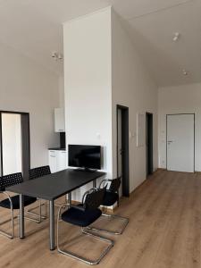 a dining room with a black table and chairs at Horgau Living in Horgau