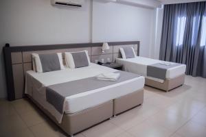 a bedroom with two beds in a room at Hospedare Hotel in Marechal Cândido Rondon +34 photos