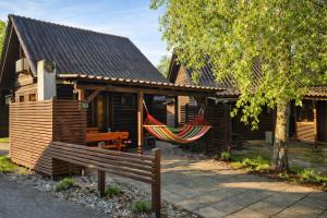 a house with a hammock hanging from the front of it at Hiška Arijela, Terme Čatež, oaza sprostitve, Slovenija in Brežice