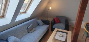 a living room with a blue couch and two chairs at Ferienwohnung Menz Liliensteinblick in Pfaffendorf
