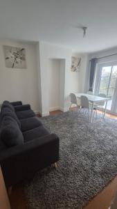 a living room with a black couch and a table at Brooklyn House in Elmers End