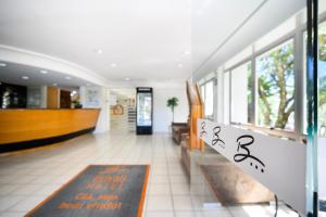 a lobby of a hotel with a sign on the wall at Brivali Hotel Centro in Caçador