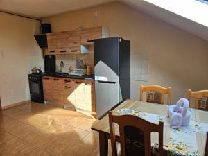 a kitchen with a refrigerator and a table with a dining room at Cudowne poddasze in Piotrków Trybunalski
