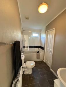 a bathroom with a toilet and a tub and a sink at Two Bedroom Lodge in Gainsborough