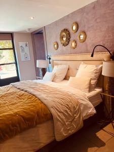 a bedroom with a large bed with two mirrors on the wall at Mas de Provence en Riviera in La Roquette-sur-Var +289 photos