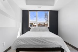 a bed in a room with a window at Lux Suites Extended Stay in Thunder Bay
