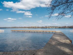 a dock on a lake with a cloudy sky at Naturelodge Kalbornia Mazury in Dąbrówno
