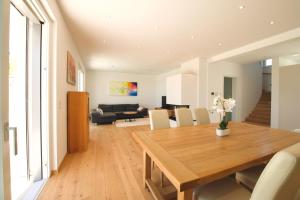 a dining room and living room with a wooden table at Villa 60, luxuriöse Villa mit Pool, Sauna und großem Garten in Gols