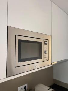 a microwave oven in a kitchen with white cabinets at Coração d`Alice in Monção