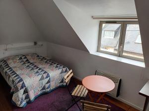 a bedroom with a bed and a table and a window at VERYAC'H in Camaret-sur-Mer