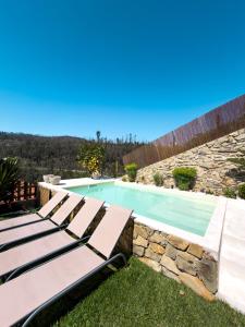 a swimming pool with lounge chairs in a yard at Douro Rural Home in Melres