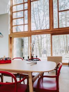 a dining room with a table and red chairs at Naturelodge Kalbornia Mazury in Dąbrówno