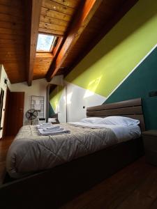 a bedroom with a bed with a green wall at Appartamento Il Loftino in Forlì