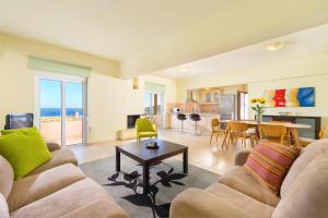 a living room with a couch and a table at Athoniki Villas in Kalathos