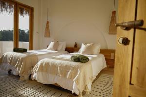 two beds with towels on them in a bedroom at Green Waves Villa in Batukaras