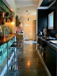 a kitchen with a stove and a counter with stools at Boutique Home in Maassluis