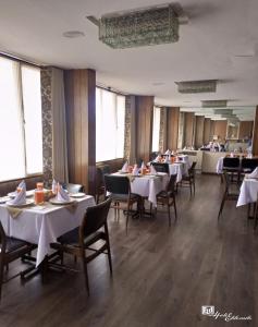 ein Esszimmer mit weißen Tischen und Stühlen in der Unterkunft Eldorado in La Paz