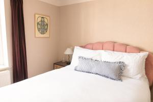 a bedroom with a large white bed with a pillow at House Arundel in Arundel