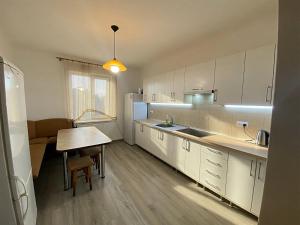 a kitchen with white cabinets and a table in it at Садиба в горах in Solochyn