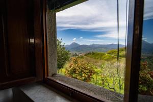 an open window with a view of the mountains at Balocco Countryside Home 1908 - Barga in Sommocolonia
