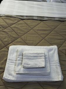 a stack of towels sitting on top of a bed at Appartamento Il Loftino in Forlì