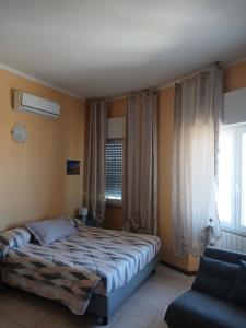 a bedroom with a bed and a window and a couch at La Torretta Sul Porto - Parcheggio gratuito in Livorno