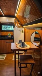 a small kitchen with a table and a mirror at Chalés da colina em Victor Graeff in Cochinho