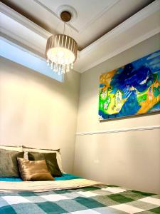 a bedroom with a bed and a painting on the wall at Solar Boutique Residence in Pouso Alegre