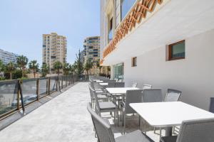 a row of tables and chairs on the balcony of a building at Minerva Hotel Kızkalesi in Kizkalesi