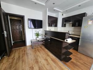 a kitchen with wooden floors and a refrigerator at Fokus-pokus in Piotrków Trybunalski