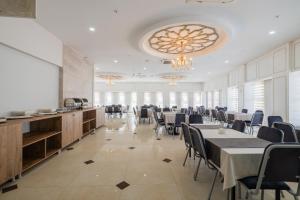 a dining room with tables and chairs and a chandelier at Minerva Hotel Kızkalesi in Kizkalesi