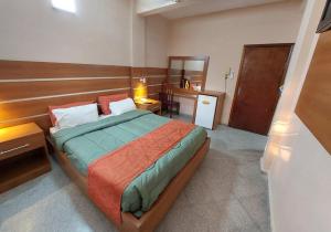 a bedroom with a bed and a desk with a mirror at Hotel Sancer in Coronel Oviedo +10 photos