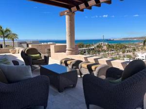 a patio with chairs and tables and a view of the ocean at Increible Casa con vista al mar in La Paz