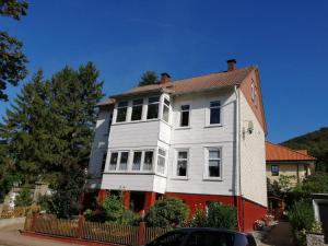 a large white house with a red at Canossa Lodge in Bad Harzburg