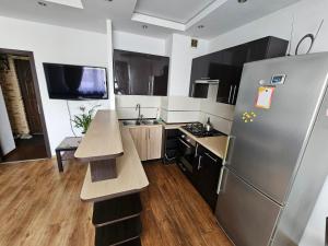 a kitchen with a stainless steel refrigerator and wooden floors at Fokus-pokus in Piotrków Trybunalski