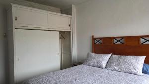 a bedroom with a bed with a wooden headboard at Alojamiento Centro de Punta Arenas in Punta Arenas