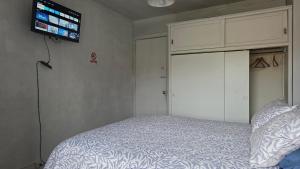 a bedroom with a bed and a tv on the wall at Alojamiento Centro de Punta Arenas in Punta Arenas