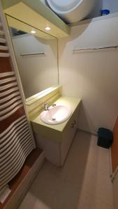 a small bathroom with a sink and a mirror at appartement 4 places centre-ville in Cauterets