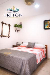 a bedroom with a bed and a sign on the wall at Hospedaje Triton in Máncora +3 photos
