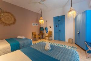 a bedroom with two beds and a table and chairs at Casa La Gloria, Centro de Mérida, Hasta 16 Huéspedes in Mérida