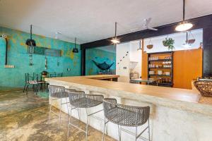 a bar in a room with blue walls and chairs at Casa La Gloria, Centro de Mérida, Hasta 16 Huéspedes in Mérida
